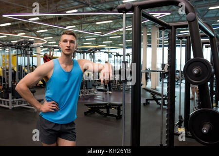 Portrait de musculaire trainer s'appuyant sur les machines de sport moderne , copy space Banque D'Images