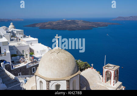 À l'église orthodoxe de bord de cratère Thira, derrière l'île volcanique de Nea Kameni, Santorini, Cyclades, Grèce, Mer Méditerranée, Europe Banque D'Images