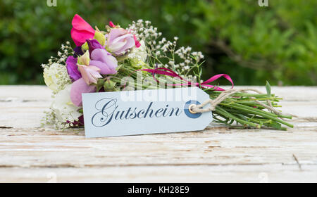 Bouquet parfumé avec des vesces et carte de souhaits avec texte allemand : carte cadeau Banque D'Images