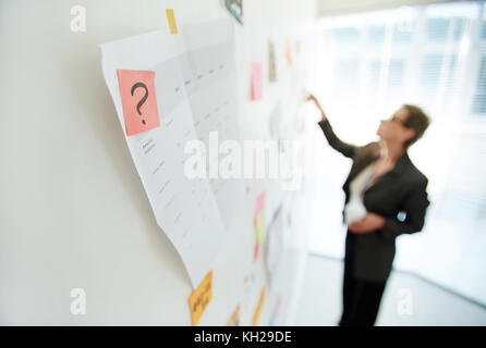 Point d'interrogation sur un papier à lettres rose épinglé sur le tableau blanc Banque D'Images