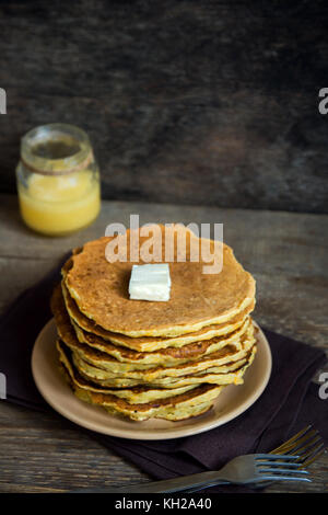 Crêpes maison avec du beurre et du miel. des crêpes pour le petit-déjeuner sur fond de bois rustique. Banque D'Images