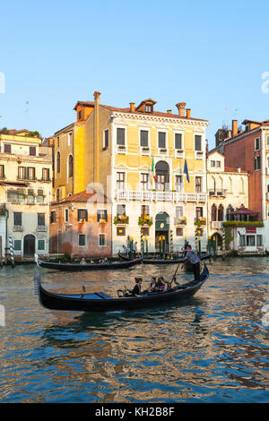 Soirée romantique en ligne dans une gondole sur le Grand Canal, le Cannaregio, Venise, Italie au coucher du soleil avec trois gondoles devant Ca Perducci Civran et Casa. Banque D'Images