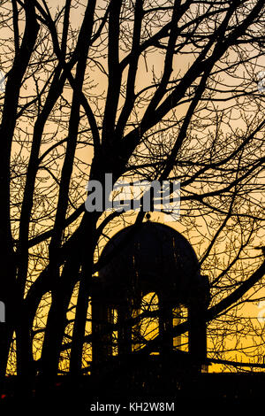 Londres, Royaume-Uni. 13 nov, 2017. Une église dome et arbres silhouetté contre un colorul lever du soleil à Wimbledon en un matin glacial froid amer : crédit ghazzal/Alamy live news Banque D'Images