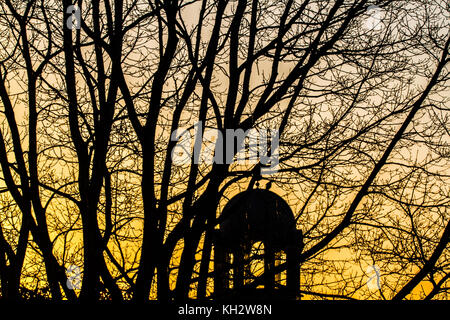 Londres, Royaume-Uni. 13 nov, 2017. Une église dome et arbres silhouetté contre un colorul lever du soleil à Wimbledon en un matin glacial froid amer : crédit ghazzal/Alamy live news Banque D'Images