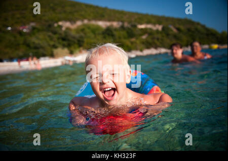 Happy boy bénéficiant d''un bain dans la mer claire Banque D'Images