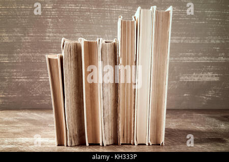 Rangée de vieux livres empilés sur fond de bois Banque D'Images