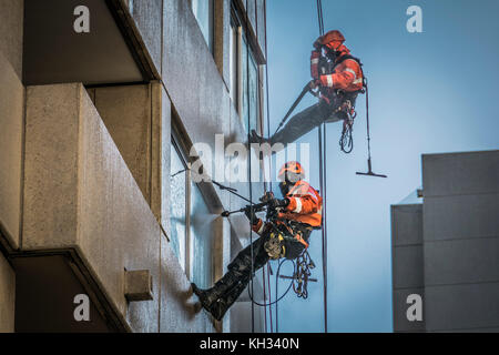 Nettoyage de vitres avec les flexibles haute pression sur un développement de grande hauteur dans le centre de Londres Banque D'Images