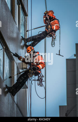 Nettoyage de vitres avec les flexibles haute pression sur un développement de grande hauteur dans le centre de Londres Banque D'Images