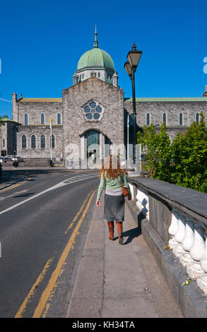 Femme irlandaise sur le pont Salmon Weir à marcher en direction de la cathédrale de Galway, comté de Galway, Irlande Banque D'Images