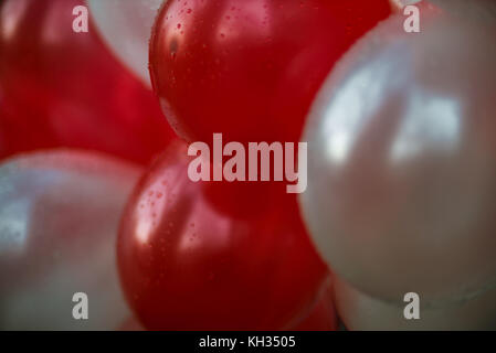 Des ballons blancs et rouges avec des gouttes de pluie Banque D'Images