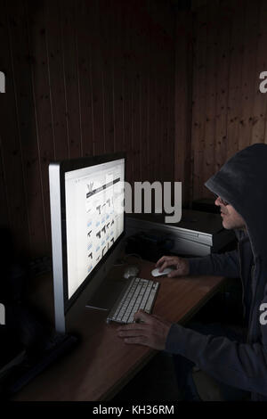 Image Concept de cyber à capuchon, l'homme criminel à l'aide d'ordinateur pour accéder à la page internet web profond offrant des armes à feu, Banque D'Images