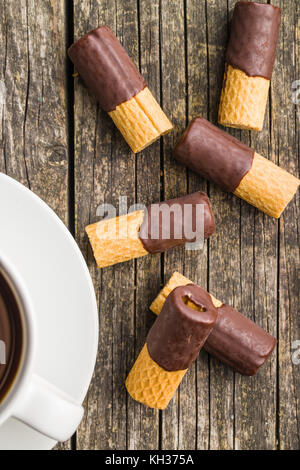 Dessert sucré. rouleaux de biscuits au chocolat avec glaçage sur vieille table en bois. Banque D'Images