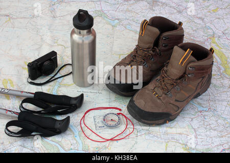 Trekking au Royaume-Uni. Bâtons de randonnée, appareil photo numérique, de l'eau fiole, compas et des bottes de randonnée figurant sur une carte de Peak District National Park Banque D'Images