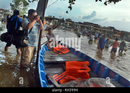 Un homme tekes une photo d'une inondation importante dans Hoi An, Vietnam Banque D'Images