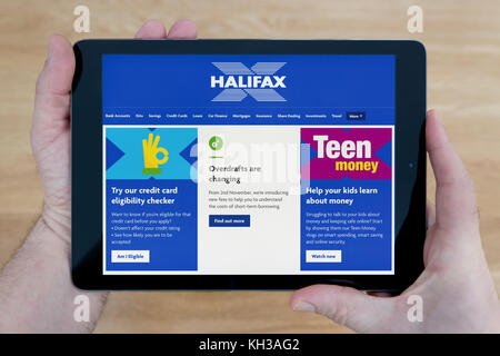 Un homme regarde le site web de la banque d'Halifax sur son iPad tablet device, tourné contre une table en bois page contexte (usage éditorial uniquement) Banque D'Images