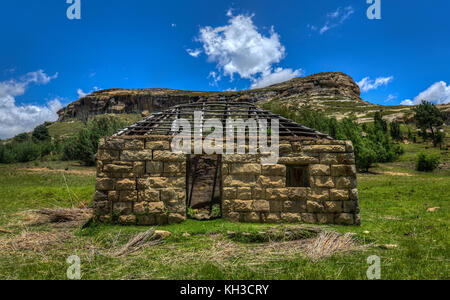 Maison construite par la moitié dans le paysage vallonné de la région Butha-buthe du Lesotho. Le Lesotho, officiellement le royaume du Lesotho, est un pays sans littoral et Banque D'Images