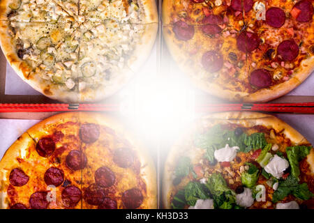 Quatre différentes boîtes à pizza - César, au salami et le poulet avec copie espace. Vue de dessus Banque D'Images