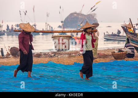 Les birmanes réunissant les nuits à terre des prises à l'aube, près du village de pêcheurs sur la plage de Ngapali en Birmanie (Myanmar). Banque D'Images