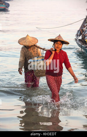 Les birmanes réunissant les nuits à terre des prises à l'aube, près du village de pêcheurs sur la plage de Ngapali en Birmanie (Myanmar). Banque D'Images