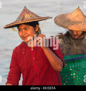 Femme birmane réunissant les nuits à terre des prises à l'aube, près du village de pêcheurs sur la plage de Ngapali en Birmanie (Myanmar). Banque D'Images