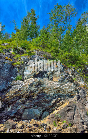 Falaise de calcaire dans les montagnes de l'Altaï (Russie) avec la forêt sur le haut - paysage d'été ensoleillée sur un fond de ciel bleu clair Banque D'Images