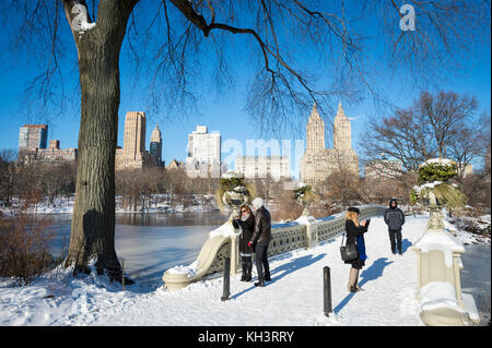 NEW YORK CITY - 8 JANVIER 2016 : vue matinale pittoresque sur les gens qui profitent d'un Bow Bridge enneigé avec vue sur le lac de Central Park Banque D'Images