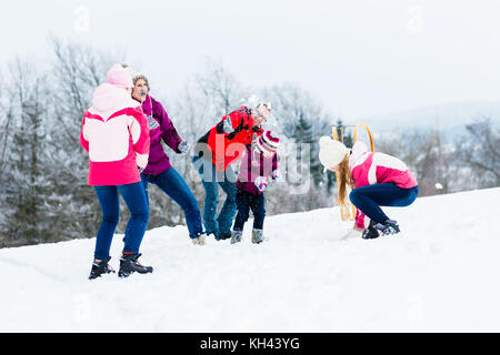 Famille avec enfants having snowball fight en hiver