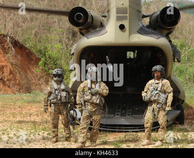 L'hélicoptère CH-47 Chinook's crew chiefs du 2e Bataillon du Régiment d'aviation de combat 501, Aviation Brigade, 1st Armored Division se préparent à partir de l'hélicoptère après avoir prononcé l'offre de nourriture et l'eau de la FEMA aux résidents de Utuado, Puerto Rico, le 18 octobre 2017, à la suite des ravages causés par l'Ouragan Maria. Banque D'Images