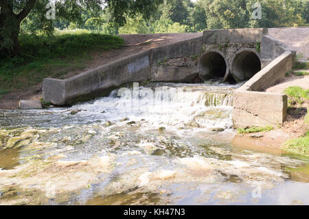 Le drainage de l'étang en pierre avec petite cascade. arrière-plan, la nature. Banque D'Images