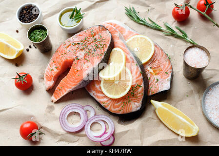 Darnes de saumon, citron, sel de mer, fines herbes, épices et huile d'olive. Prête pour la cuisson du poisson. La saine alimentation, la cuisson des aliments et les régimes amaigrissants concept Banque D'Images