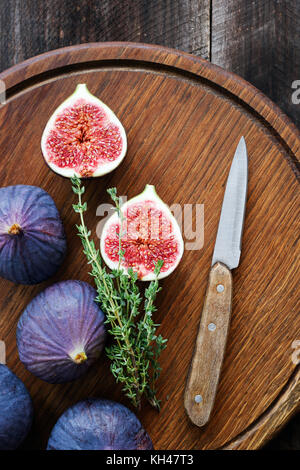 Figues violettes sur planche à découper en bois. Figues fraîches prêtes pour la cuisson. Vue d'en haut Banque D'Images