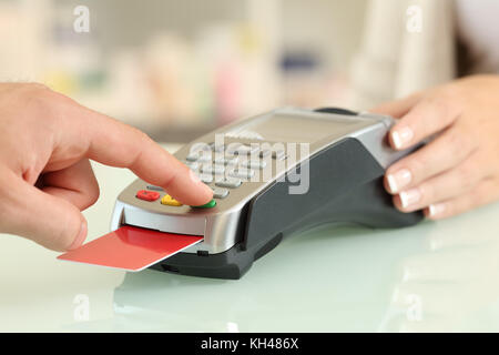 Close up d'un doigt de l'homme saisie du mot de passe de payer par carte de crédit sur un comptoir d'une boutique Banque D'Images