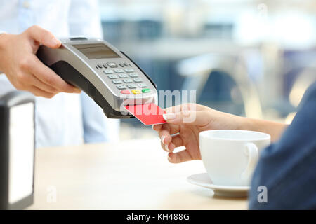 Close up of a customer woman paying with credit card reader dans un bar Banque D'Images