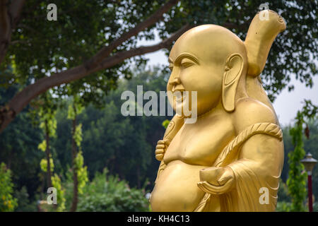 Golden laughing Buddha sculpture à wat thai au monastère bouddhiste de Sarnath, Varanasi Banque D'Images