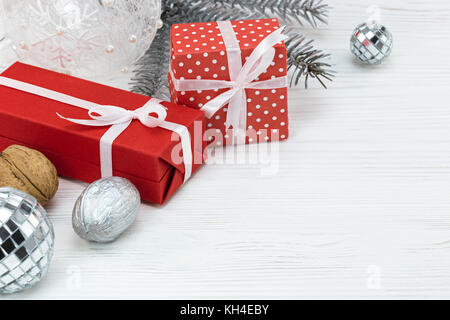 Cadeaux rouge avec des décorations de noël et le sapin arbre branche sur fond de bois blanc Banque D'Images