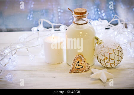 Une bouteille de lait, des boules et une bougie sur la table Banque D'Images