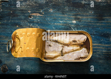 Sardines dans la pouvez sur table en bois bleu Banque D'Images