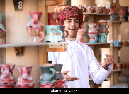 Jeune garçon omanais effectuant un morceau dans une tenue traditionnelle. Nizwa, Oman. Banque D'Images