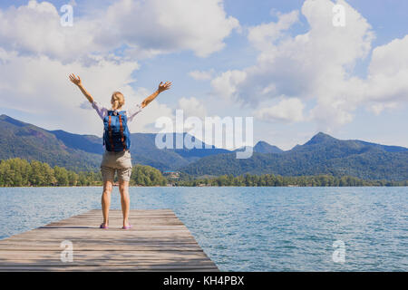 Happy female traveler avec sac à dos raising arms après l'arrivée à destination de voyage tropical paradise Banque D'Images