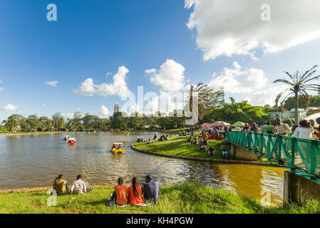 Personnes à pied et assis dans Uhuru Park par le lac de plaisance regardant peddle bateaux, Nairobi, Kenya Banque D'Images