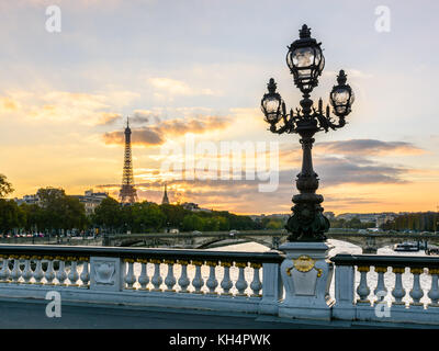 L'un des lampadaires de style Art Nouveau du pont Alexandre III à Paris avec la Tour Eiffel en arrière-plan au coucher du soleil. Banque D'Images