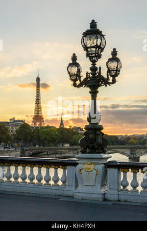 L'un des lampadaires de style Art Nouveau du pont Alexandre III à Paris avec la Tour Eiffel en arrière-plan au coucher du soleil. Banque D'Images