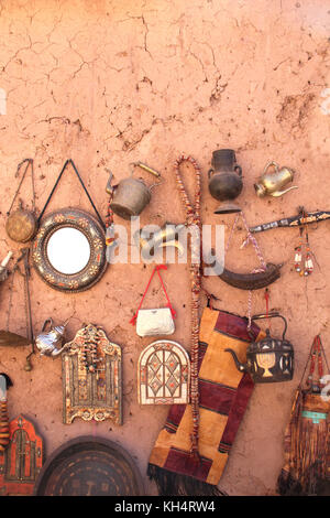 Souvenirs traditionnels marocains - poignard, électrique, jug, fenêtre-miroir avec volets sur mur d'argile, souk à ait-ben-haddou kasbah, Maroc, afrique du nord Banque D'Images