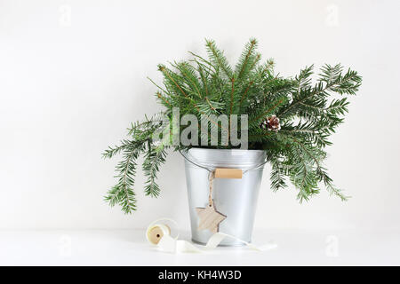 Branches de sapin vert métalique en godet. christmas cocottes, Star et le tiroir de ruban blanc, allongé sur la table de la nature morte, Banque D'Images