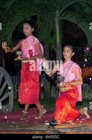 Les jeunes filles cambodgiennes pétales jeter dans le cadre d'un spectacle de danse traditionnelle Banque D'Images