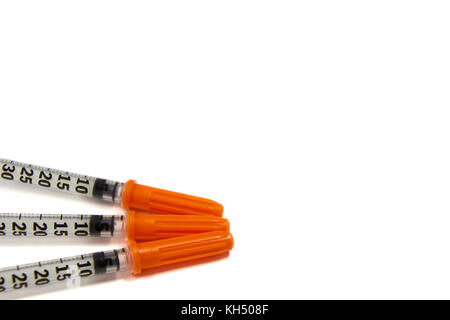 Les seringues d'injection d'insuline pour le diabète patient à contrôler leur glycémie sur fond blanc, selective focus Banque D'Images