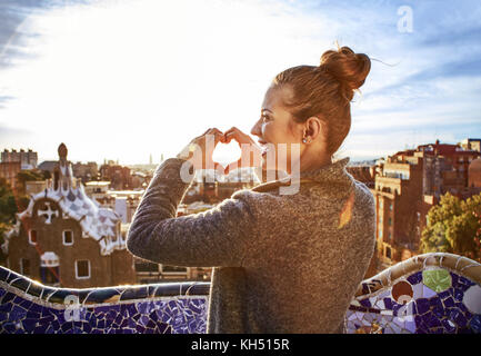 Style signature de Barcelone. vu de dos jeune femme manteau en tourisme à Barcelone, Espagne montrant les mains en forme de coeur Banque D'Images