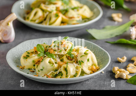 Les tortellinis farcis ail et oignon frit avec épinards Banque D'Images