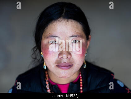 Portrait d'une femme nomade tibétain avec ses joues rougies par le mauvais temps, la province de Qinghai, Tsekhog, Chine Banque D'Images