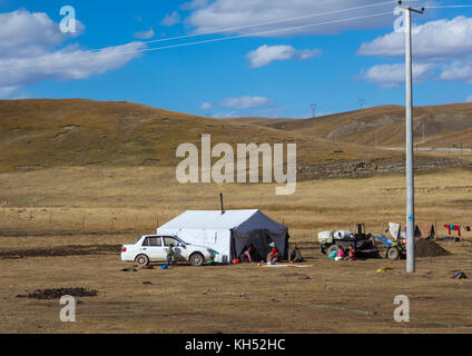 Famille de nomades tibétains vivant dans une tente dans la prairie, la province de Qinghai, Tsekhog, Chine Banque D'Images